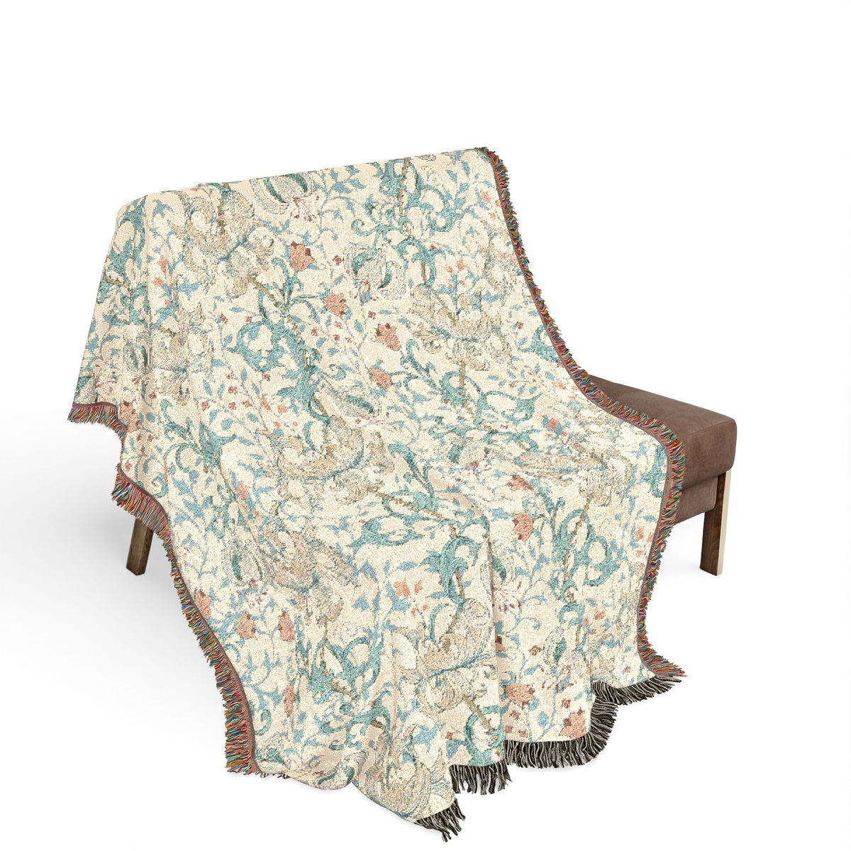 A woven throw blanket with a detailed botanical and bird pattern draped over a brown armchair against a solid white background.