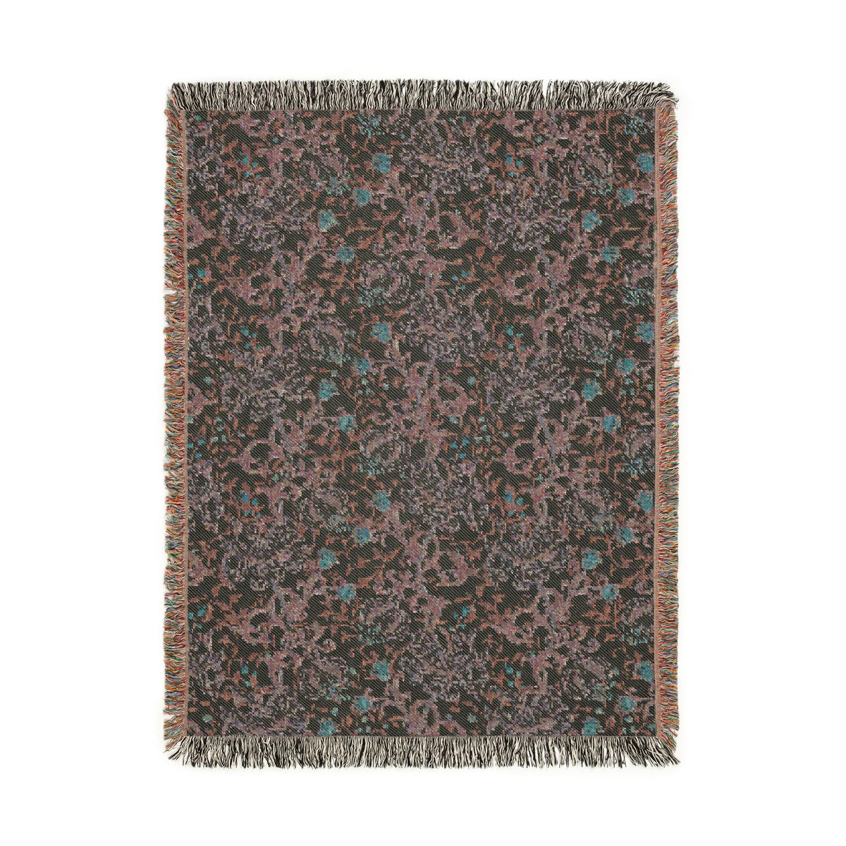 A rectangular woven throw blanket with fringed edges, featuring an abstract floral pattern in dusty pink, teal blue, and light gray on a dark charcoal background.