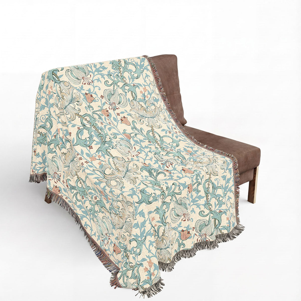 A woven throw blanket with a floral and bird pattern draped over a brown armchair against a plain white background.