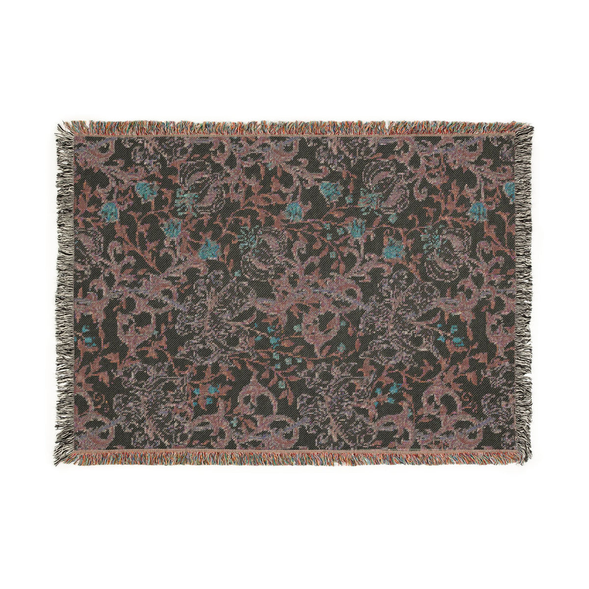 A rectangular woven throw blanket with fringe on all sides, featuring an intricate floral and scroll pattern in muted pink, teal blue, and gray on a dark charcoal background.