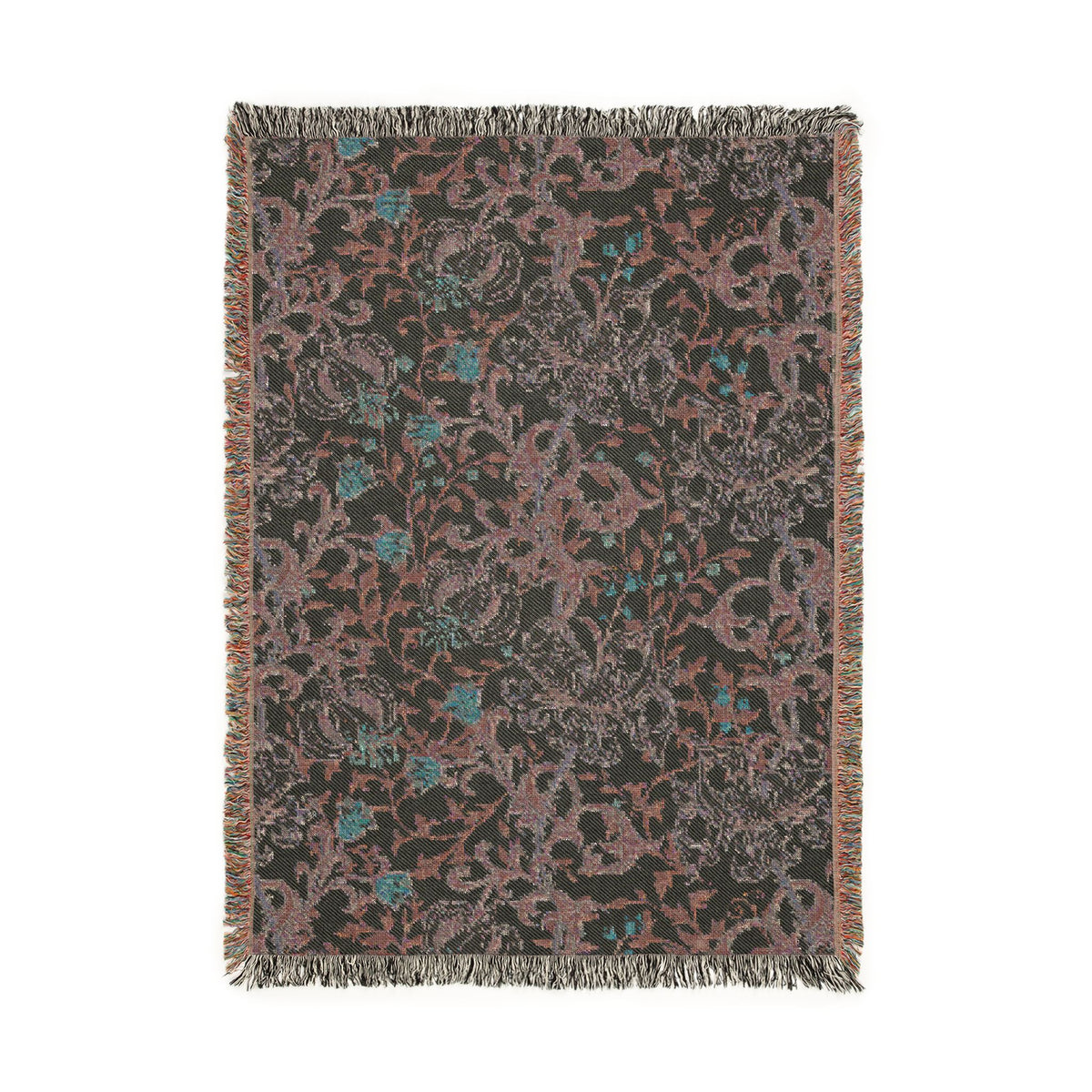 A rectangular woven throw blanket with fringe on all sides, featuring an intricate floral and scroll pattern in muted dusty pink, teal blue, and gray on a dark charcoal background.