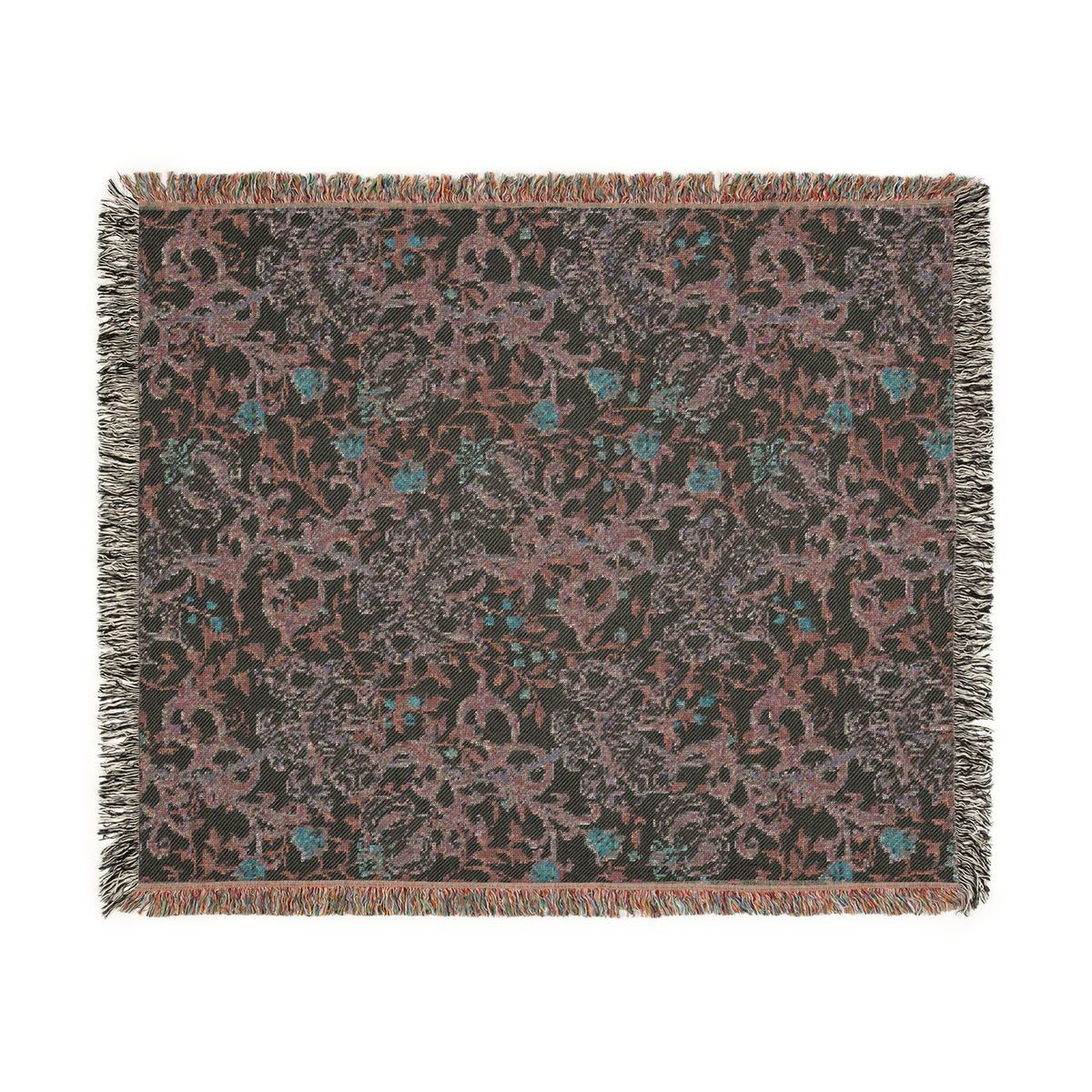 A rectangular woven throw blanket with fringed edges, featuring an intricate floral and vine pattern in muted pink, teal blue, and gray on a dark charcoal background.