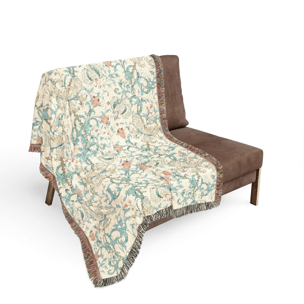 A woven throw blanket with a detailed botanical pattern draped over a brown armchair, shown against a plain white background.