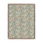 A rectangular woven throw blanket with a cream background and an intricate botanical pattern in teal, sage green, and terracotta, finished with fringed edges.