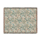 A rectangular woven throw blanket with a detailed floral and paisley pattern in teal, rust orange, and beige, finished with fringed edges.