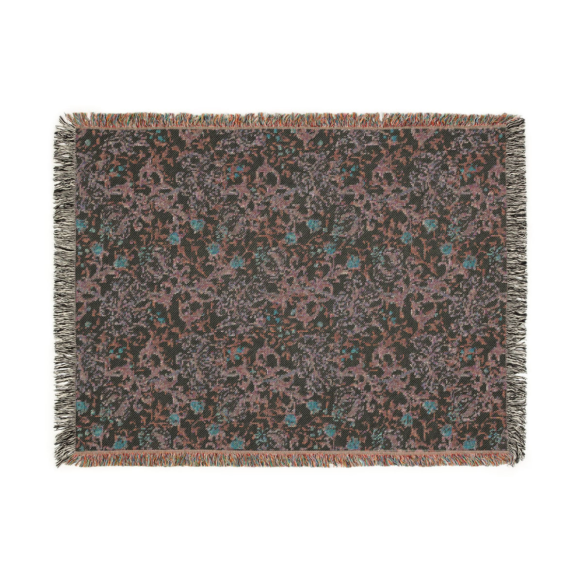 A rectangular woven throw blanket with fringed edges, featuring an intricate abstract floral pattern in muted pink, teal blue, and light gray on a dark charcoal background.