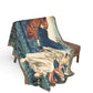 Decorative throw blanket with artistic design draped over a chair on a white background