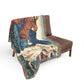 Decorative tapestry blanket with classical scene draped over a brown chair on a white background