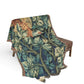Decorative blanket with nature-themed design draped over a chair on a white background