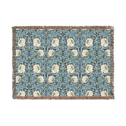 A woven cotton blanket with a geometric William Morris & Co pattern in shades of blue and beige, featuring colourful fringed edges.