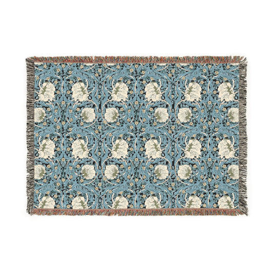 A woven cotton blanket with a geometric William Morris & Co pattern in shades of blue and beige, featuring colourful fringed edges.