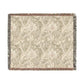 A woven cotton blanket with a floral pattern in shades of green and beige, with a colorful fringed edge.