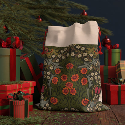 A rectangular Christmas-themed linen drawstring bag with a floral pattern, primarily in green and red colours, and a red drawstring at the top.