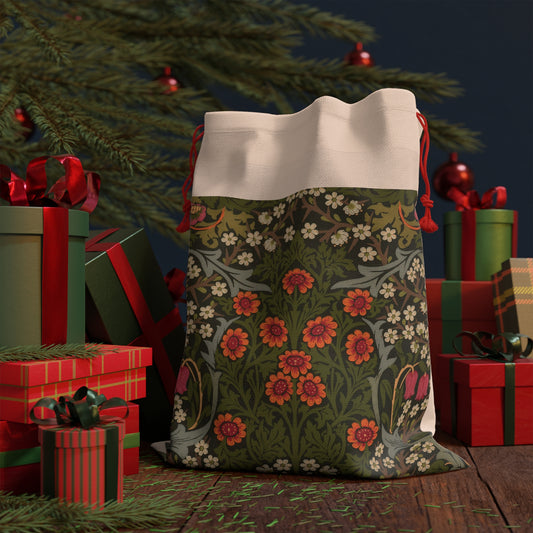 A rectangular Christmas-themed linen drawstring bag with a floral pattern, primarily in green and red colours, and a red drawstring at the top.