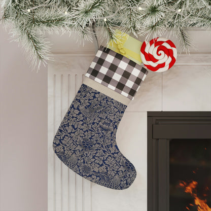 A one-sided print Christmas stocking with a geometric William Morris & Co floral pattern in blue, beige, and red colours, featuring a polyester plaid design top cuff and a wooden hanging loop.
