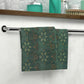 A face cloth with a floral pattern inspired by William Morris, hanging on a towel bar in a bathroom setting.
