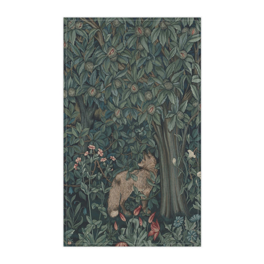 A kitchen tea towel featuring an artistic design with green foliage and a fox among the leaves.