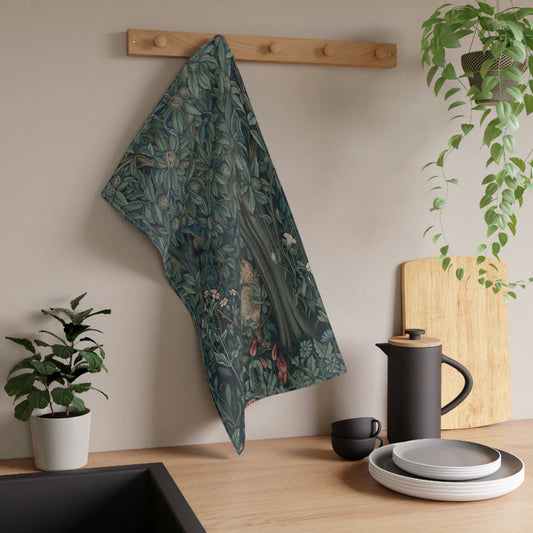 A kitchen tea towel featuring an artistic design with green foliage and a fox among the leaves.