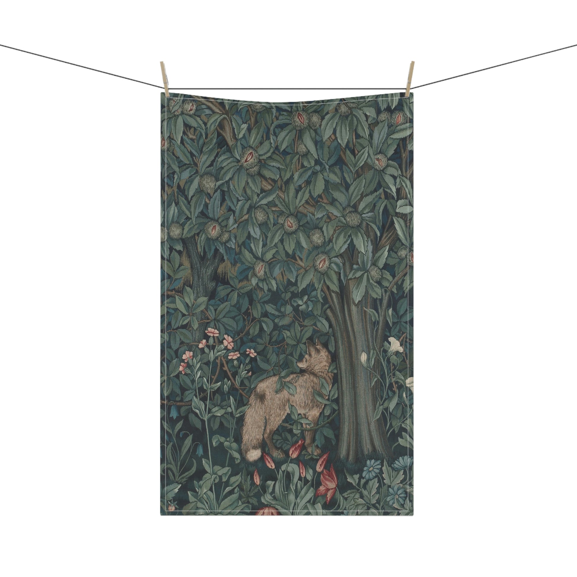 A kitchen tea towel featuring an artistic design with green foliage and a fox among the leaves.