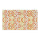 A kitchen tea towel with a floral William Morris  & Co pattern in orange, green, and yellow colours on a light background. 