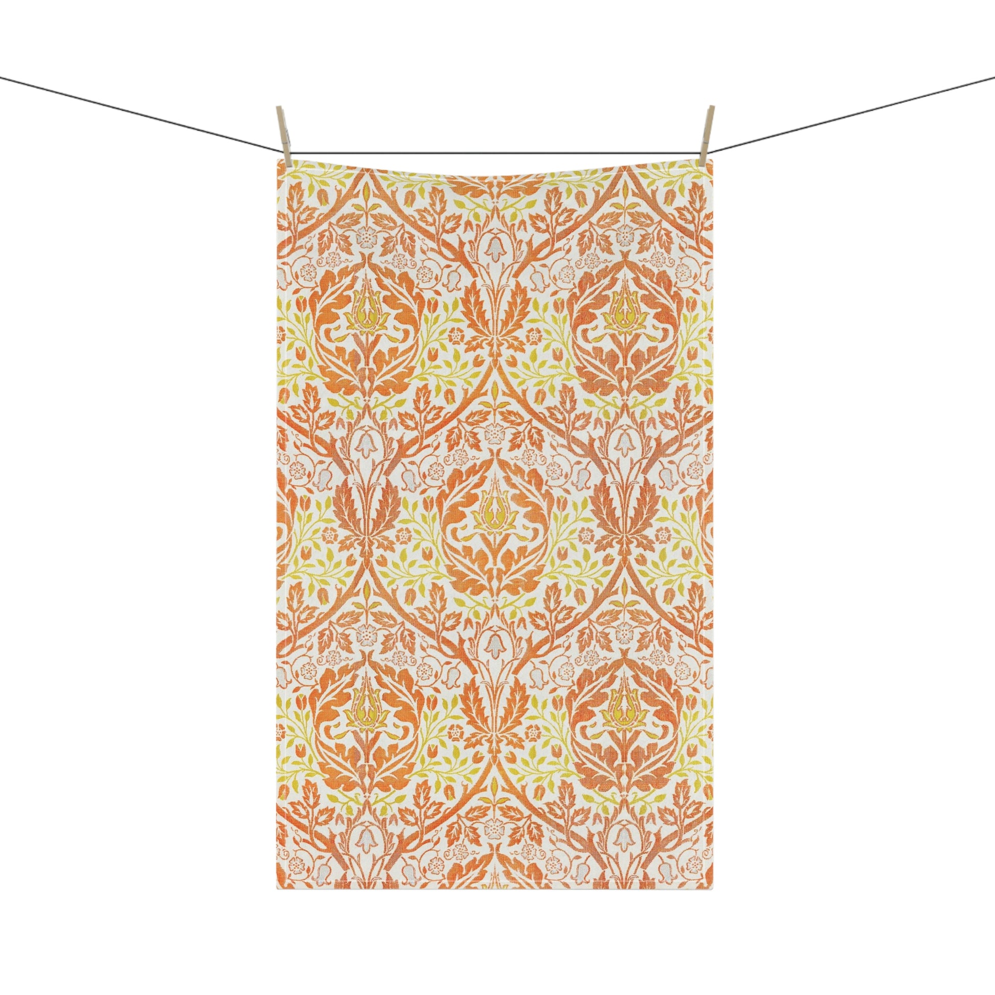 A kitchen tea towel with a floral William Morris  & Co pattern in orange, green, and yellow colours on a light background. 