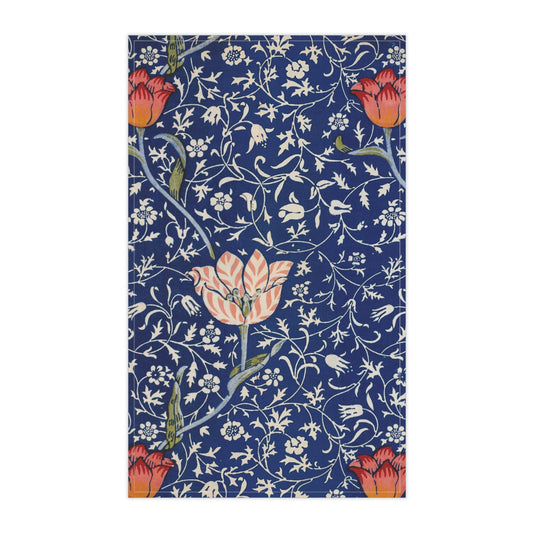 A kitchen tea towel with a blue background featuring William Morris & Co floral and geometric Art Nouveau patterns.