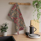 A kitchen tea towel with a red floral pattern inspired by William Morris - Wandle Collection.
