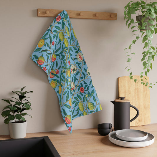 A kitchen tea towel with a blue background featuring a detailed floral and fruit pattern inspired by William Morris - Four Fruits Collection.
