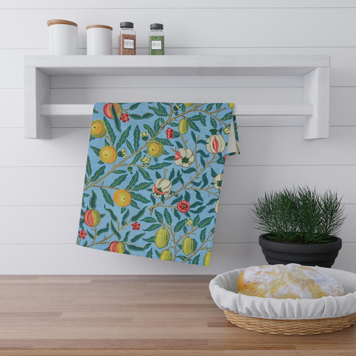 A kitchen tea towel with a blue background featuring a detailed floral and fruit pattern inspired by William Morris - Four Fruits Collection.