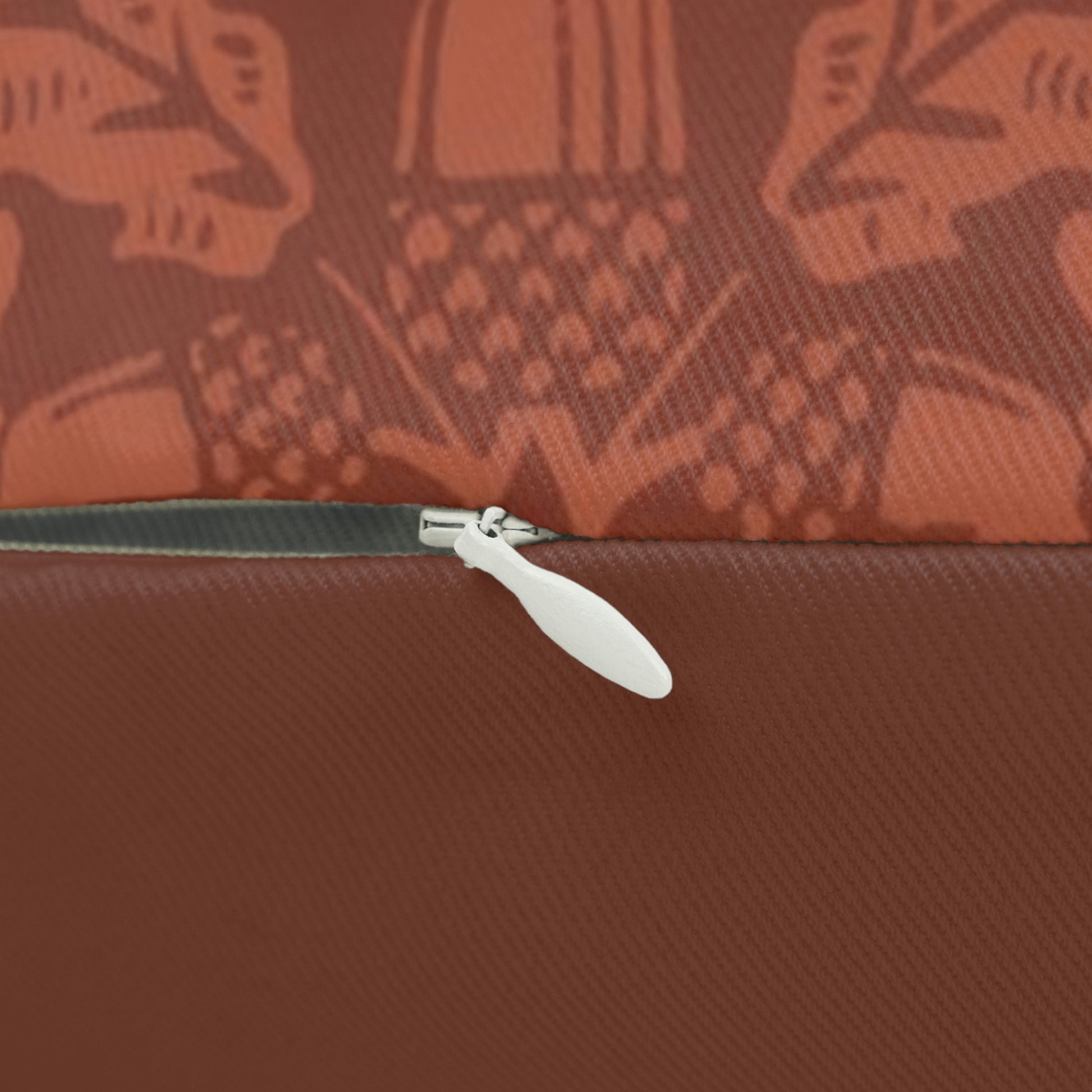 A rectangular lumbar cushion with a William Morris & CO floral pattern in a rust colour, featuring acorn and oak leaves, with a visible hidden zipper.