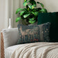 A lumbar cushion with a William Morris & Co floral and animal pattern, featuring a deer and tree in a garden setting.