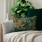 A lumbar cushion featuring a hidden beige zipper with a William Morris & Co design of a pheasant among green leaves on a background with a similar leaf pattern.