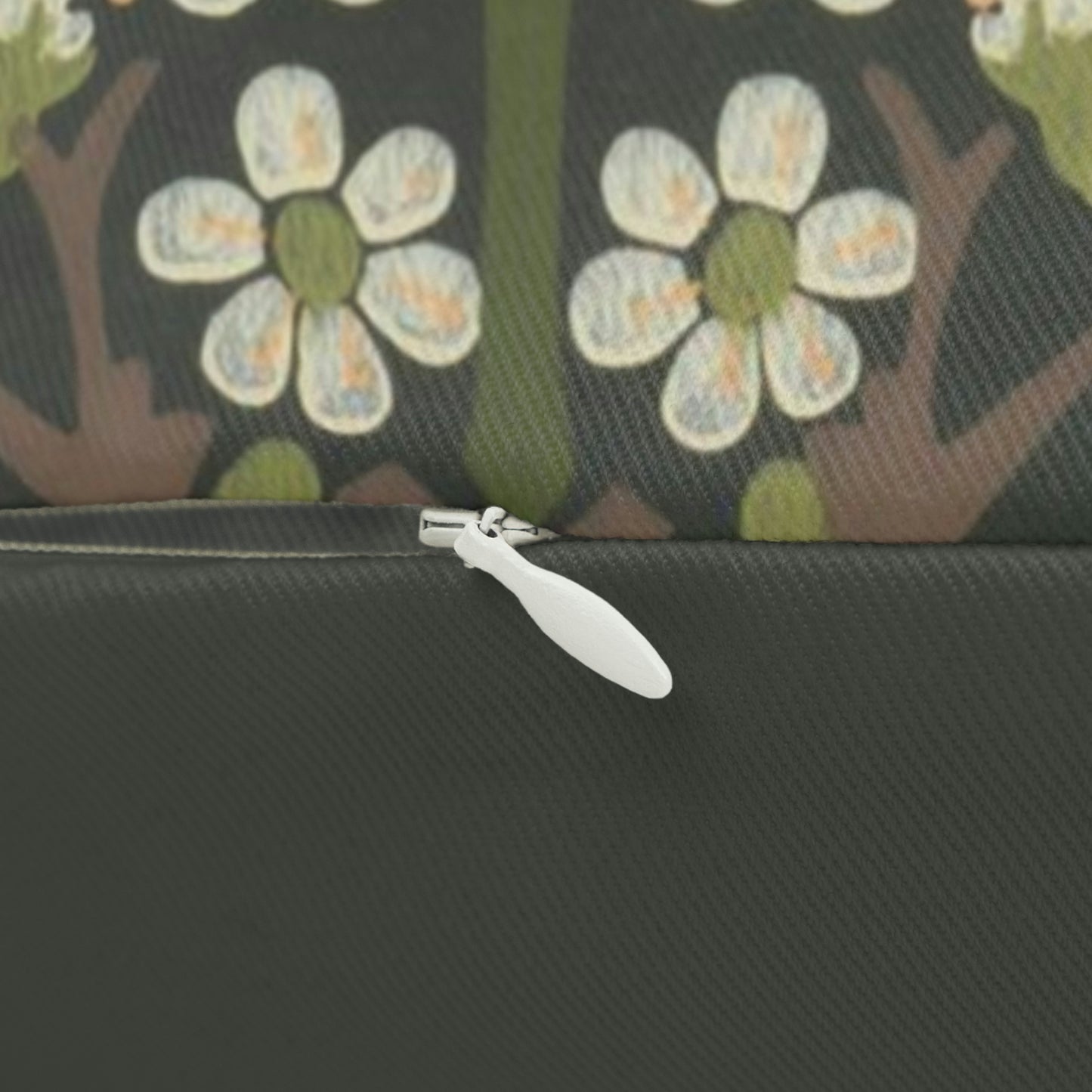 A rectangular lumbar cushion with a floral William Morris & Co pattern featuring predominantly green, with accents of red, yellow and blue.