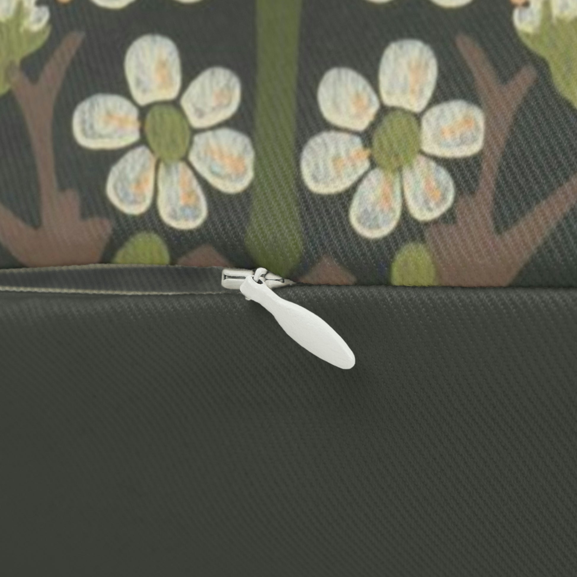 A rectangular lumbar cushion with a floral William Morris & Co pattern featuring predominantly green, with accents of red, yellow and blue.