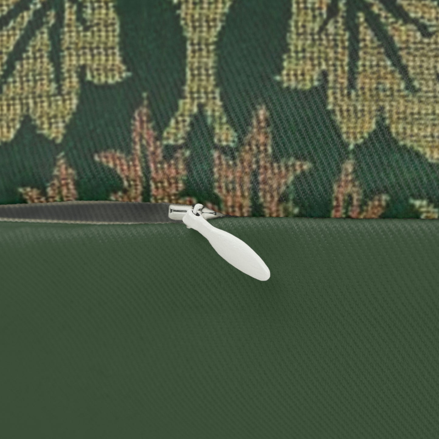 A rectangular lumbar cushion with a floral William Morris & Co pattern design in green, beige, and brown colours, featuring a concealed beige zipper.