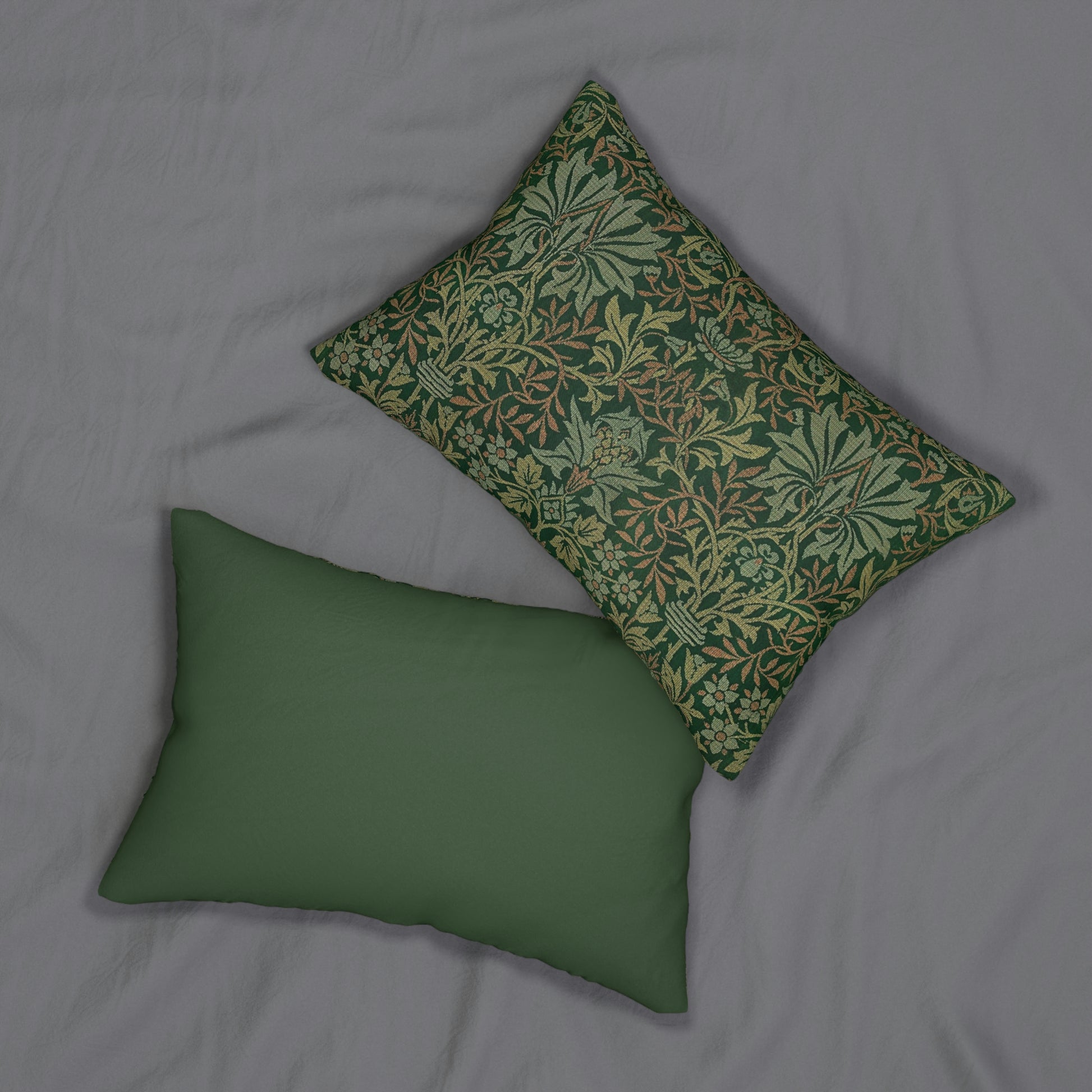 A rectangular lumbar cushion with a floral William Morris & Co pattern design in green, beige, and brown colours, featuring a concealed beige zipper.