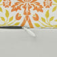 A rectangular lumbar cushion with a William Morris & Co floral pattern in shades of orange, beige, and yellow, featuring a concealed zipper.