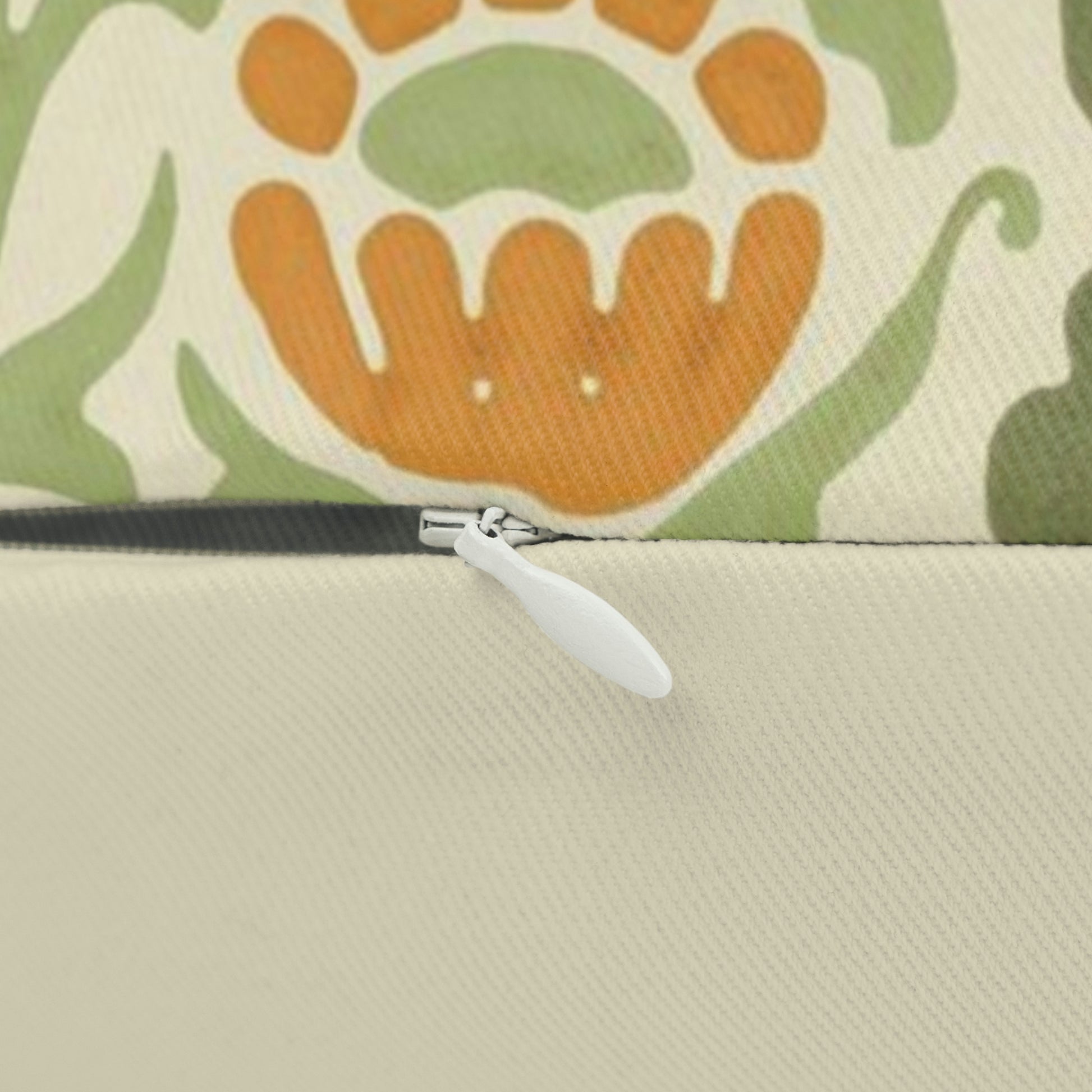 A rectangular lumbar cushion with a William Morris & Co floral pattern in green, beige, and orange colours, featuring a concealed zipper.