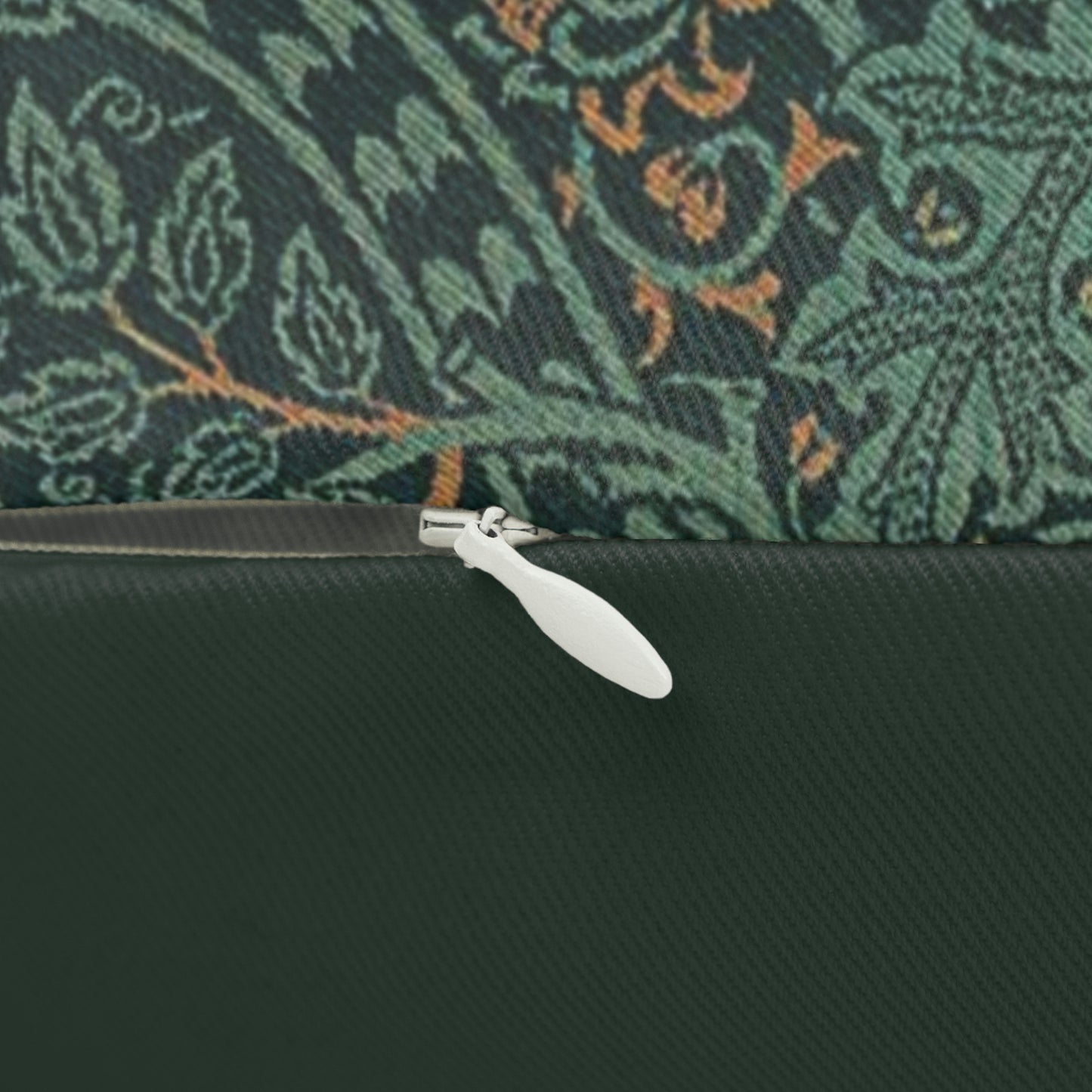 A rectangular lumbar cushion with a William Morris & Co floral pattern in shades of green and beige, featuring a concealed zipper.