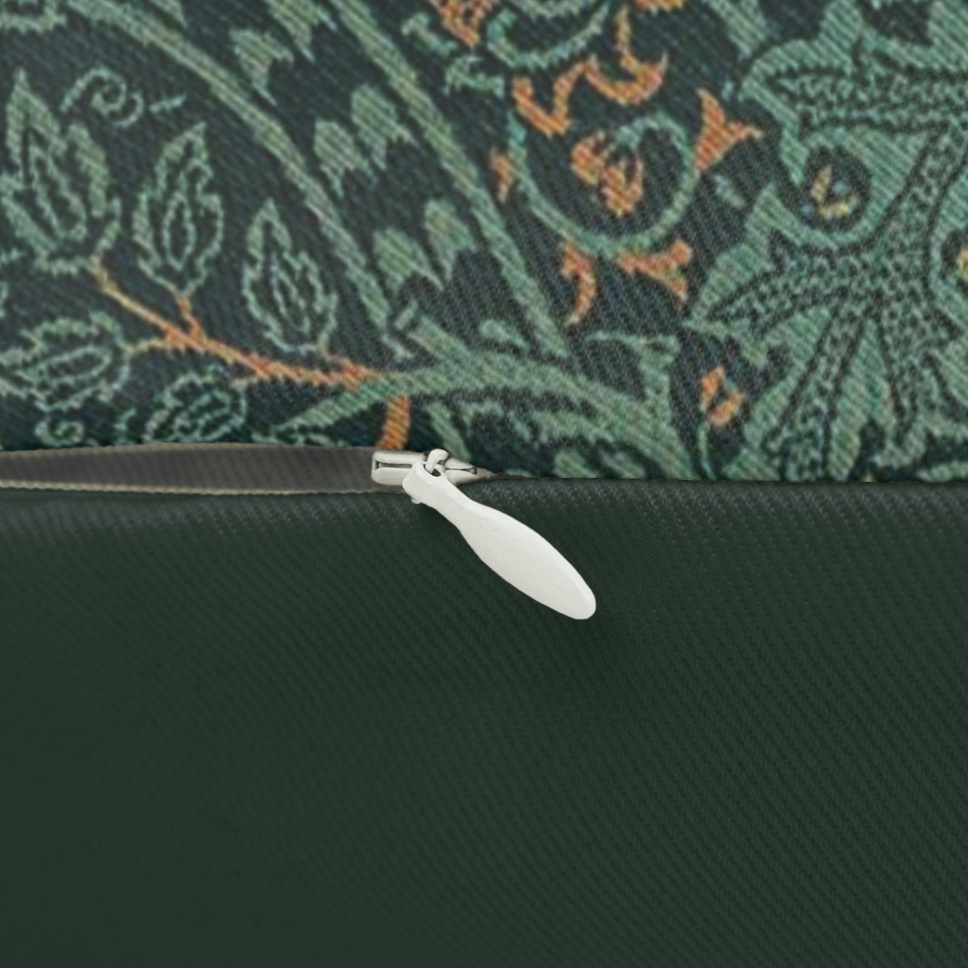 A rectangular lumbar cushion with a William Morris & Co floral pattern in shades of green and beige, featuring a concealed zipper.