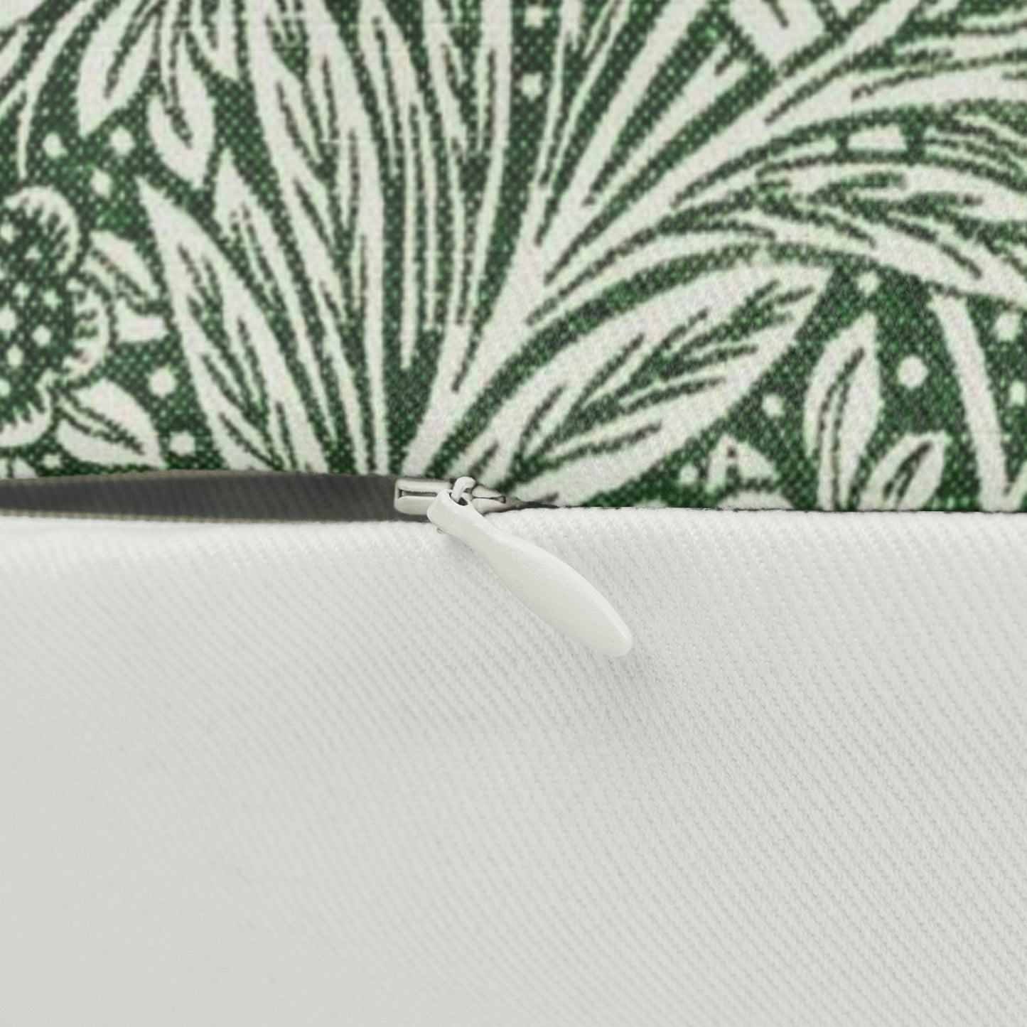 A rectangular lumbar cushion with a green William Morris & Co floral pattern on a white background, featuring a concealed beige zipper.