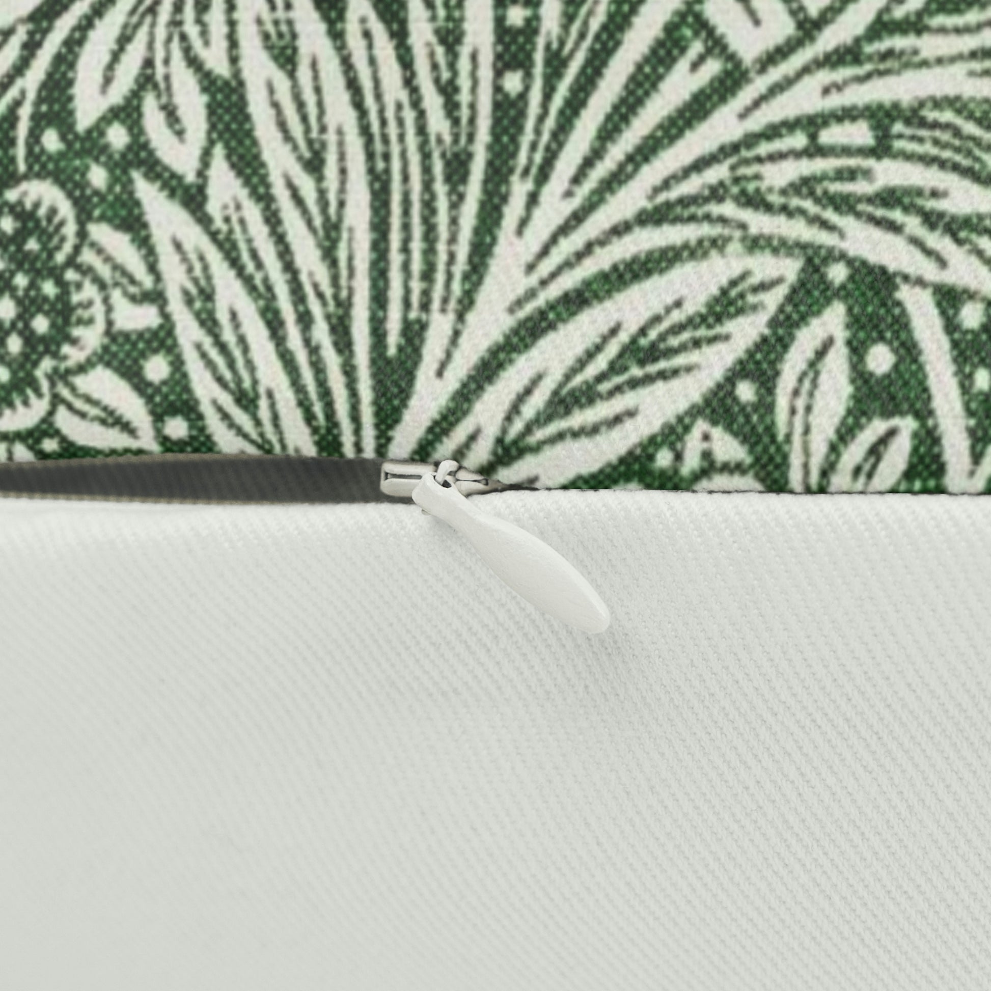 A rectangular lumbar cushion with a green William Morris & Co floral pattern on a white background, featuring a concealed beige zipper.