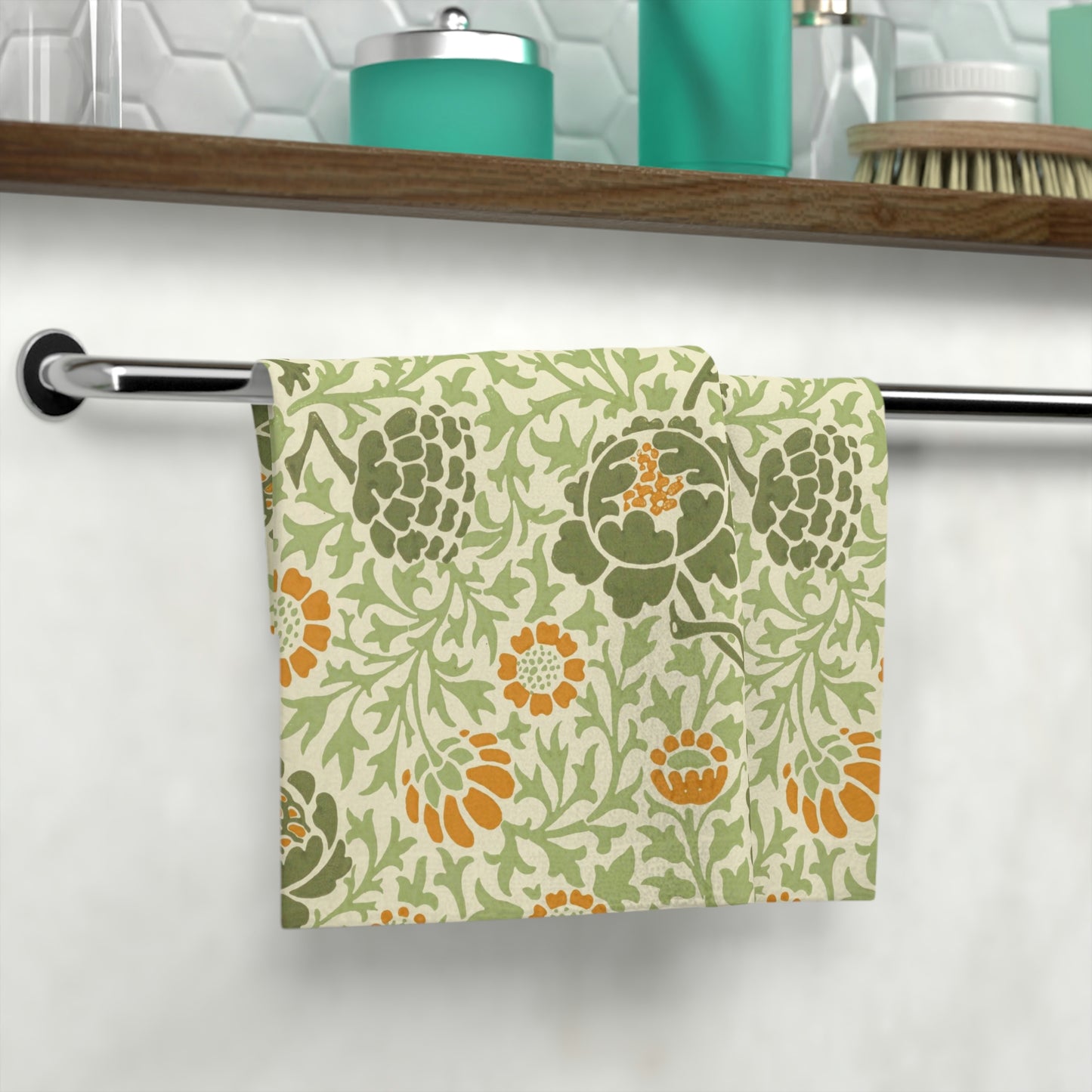 A white washcloth with a floral pattern inspired by William Morris, featuring green and orange colours.