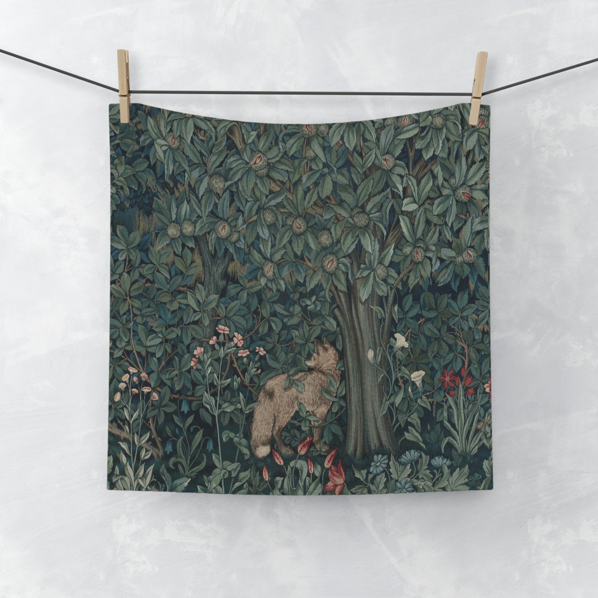 A white washcloth with a floral pattern inspired by William Morris, featuring a greenery background with a fox design.
