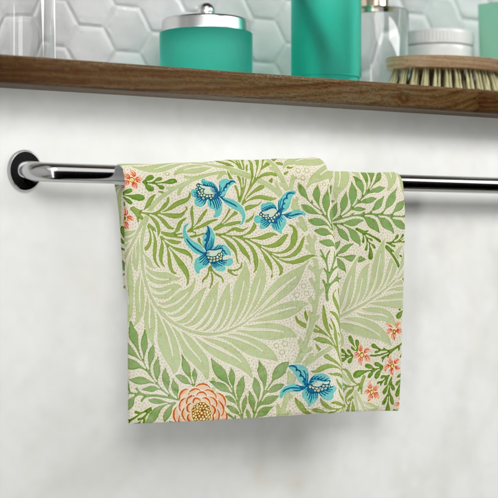 A white washcloth with a floral William Morris & Co pattern inspired by William Morris, featuring green leaves and blue flowers.