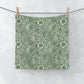A white washcloth with a green floral pattern inspired by William Morris's art.