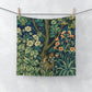 A white washcloth with a floral pattern inspired by William Morris, featuring an illustration of squirrels and leaves.